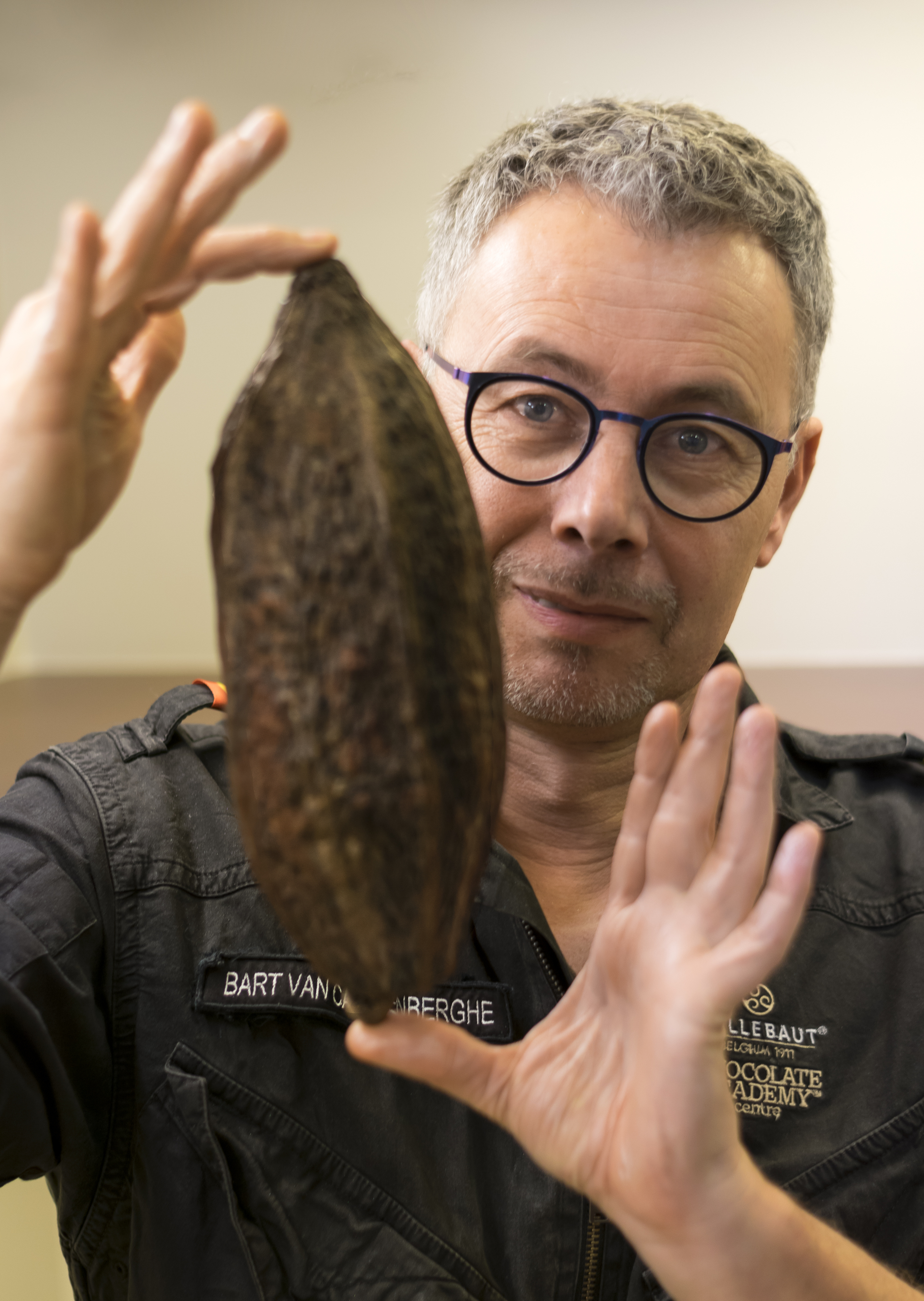 Chocolatier Deinze Bart Van Cauwenberghe met cacaovrucht in atelier